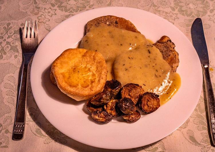Fried pork chop in cognac gravy sauce with Yorkshire pudding and Baked Brussel Sprouts