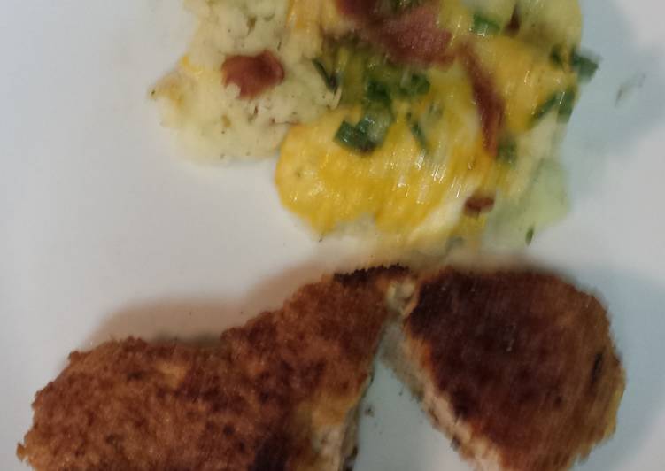 Breaded pork loin chops with a side of mashed potatoes topped with bacon, cheese,green onion